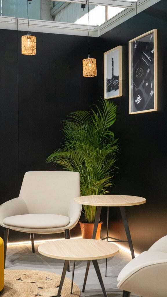 Fondo de pared negra con helecho y sillas con mesas blancas